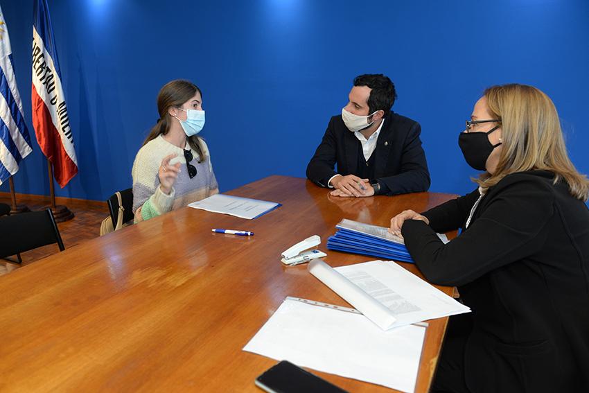 Persona beneficiaria de la beca, Director de Educación y encargada de la Oficina de becas firmando