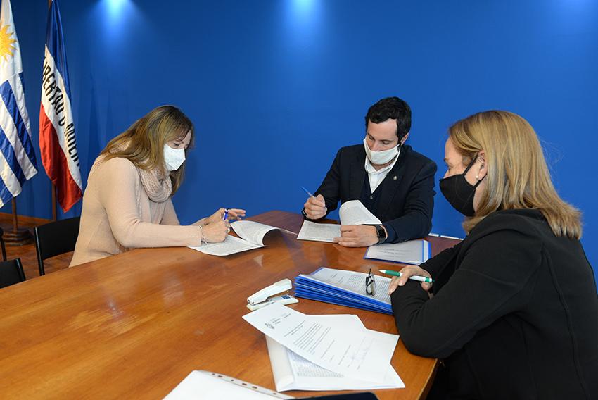 Persona beneficiaria de la beca, Director de Educación y encargada de la Oficina de becas firmando