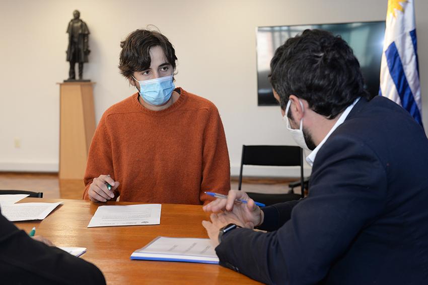 Persona beneficiaria de la beca y Director de Educación firmando el contrato Persona beneficiaria de la beca, Director de Educación firmando contrato