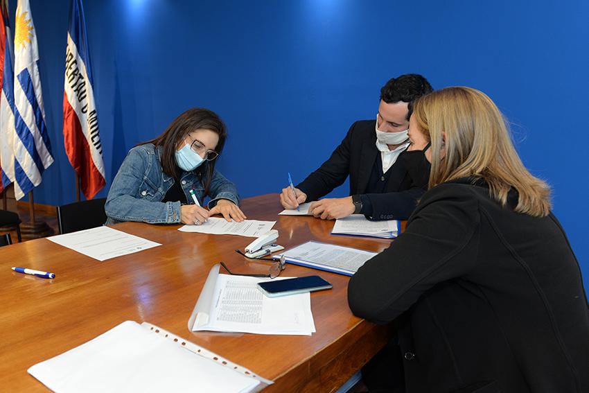 Persona beneficiaria de la beca, Director de Educación y encargada de la Oficina de becas firmando e Persona beneficiaria de la beca, Director de Educación y encargada de la Oficina de becas firmando