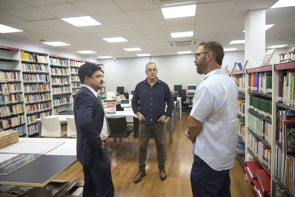 Ministro en ronda hablando con personas en una biblioteca