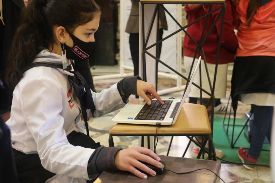 Niña con tapaboca mirando una computadora Niña con tapaboca mirando una computadora