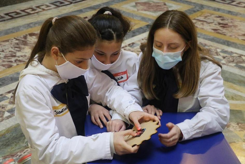 Tres niñas con tapaboca mirando una placa Tres niñas con tapaboca mirando una placa