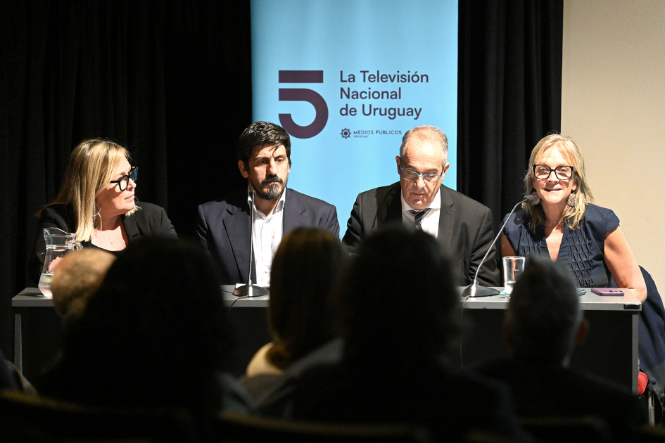 Personas hablando al público en escenario.