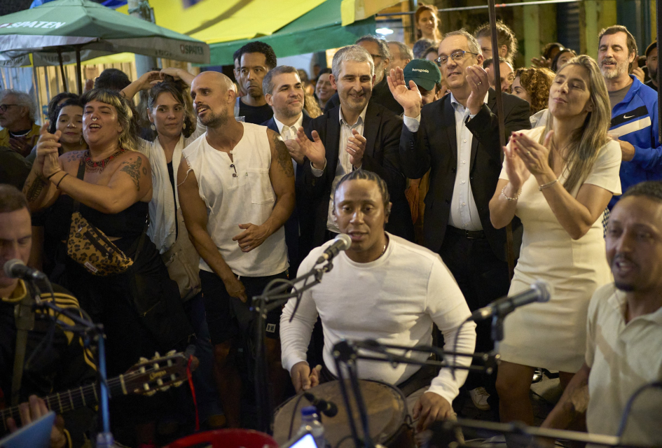 Hombre tocando el tambor con un grupo de gente detrás