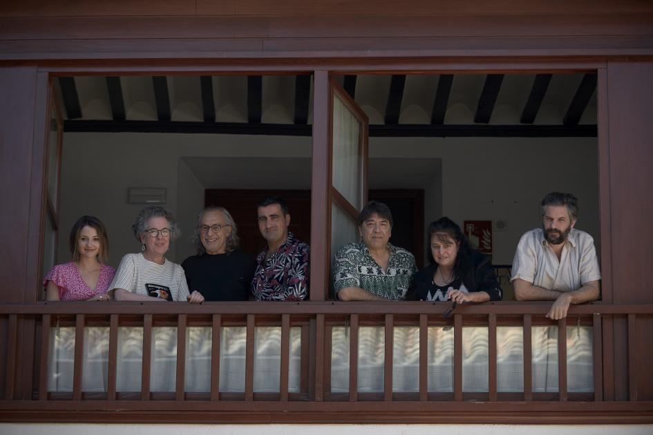 Wainstein junto al director del Festival y artistas. Personas asomadas de un balcón.