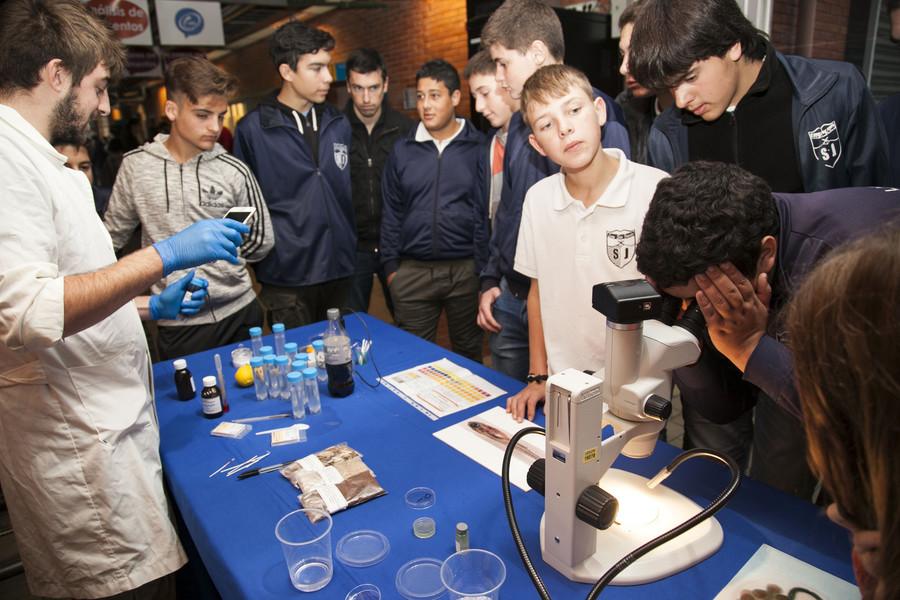 semana ciencia y tecnología jóvenes frente a a docente con experimentos de química