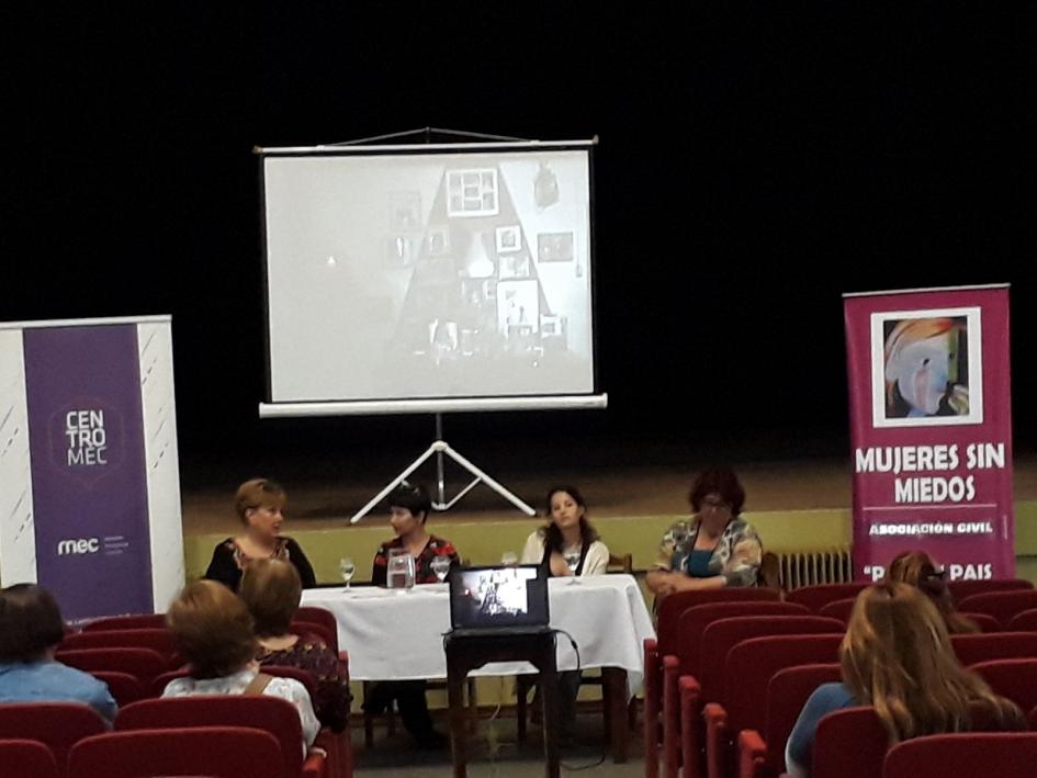 Presentación de la muestra Personas en mesa hablan al público