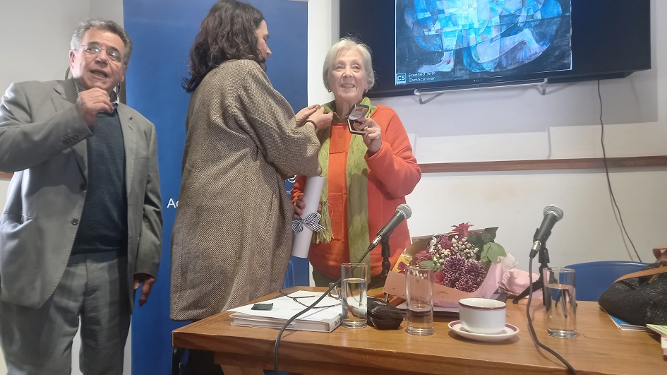 Magdalena Coll (Secretaria ANL) entregando Medalla y Pin de la Institución