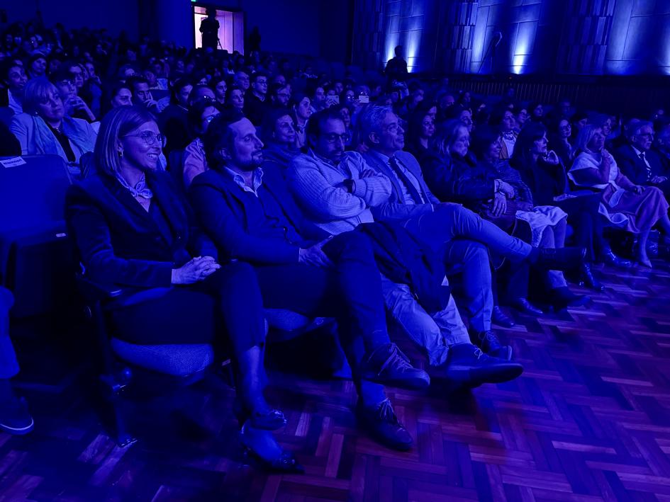 Sala llena de gente asistiendo el evento