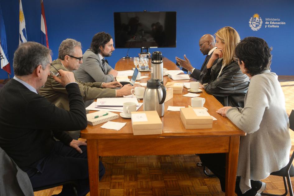 Personas sentadas alrededor de una mesa con documentos