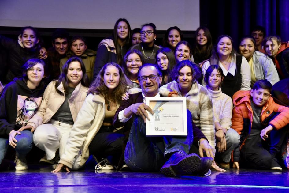 Ceremonia del Premio ReachingU al docente uruguayo 2022 Persona ganadora rodeada de escolares