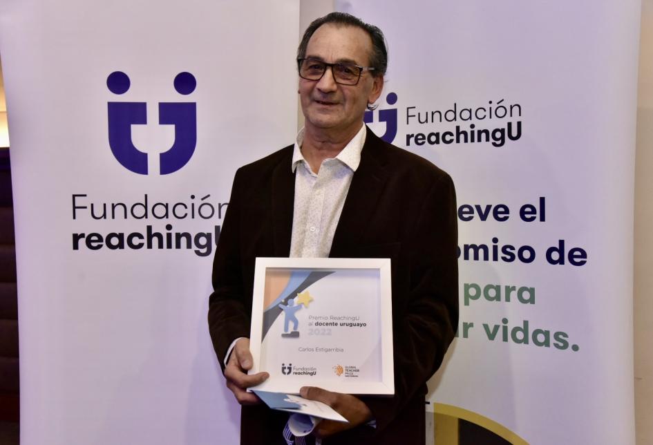 Ceremonia del Premio ReachingU al docente uruguayo 2022 Persona ganadora exhibiendo su premio