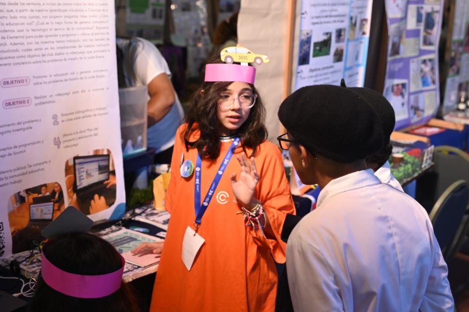 Niños de edad escolar conversando en una feria de ciencia