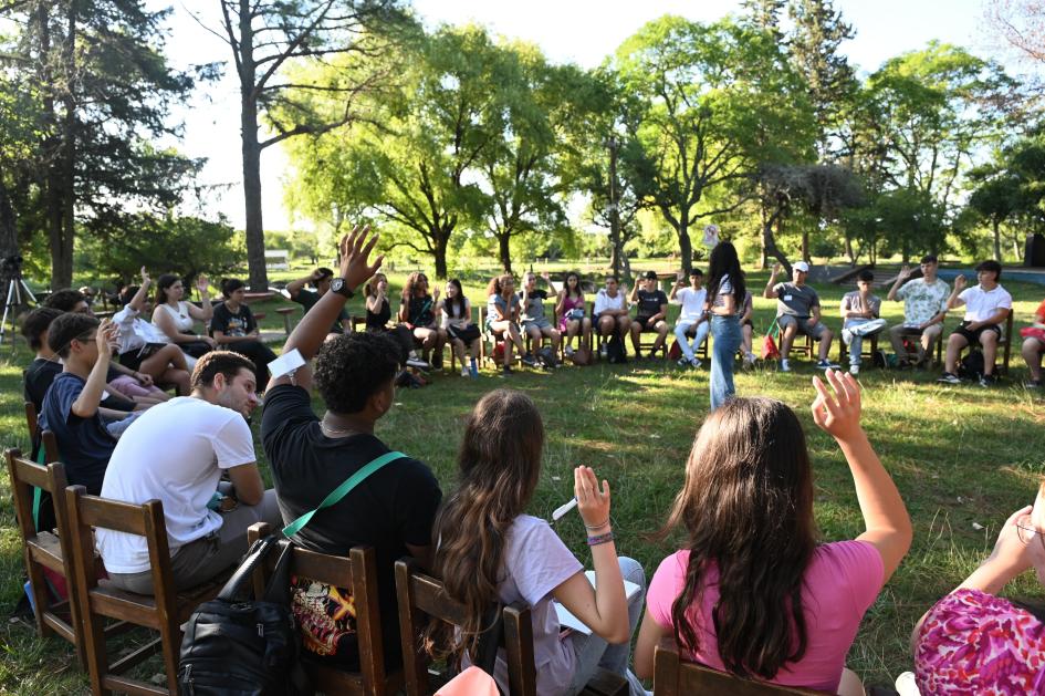 Jóvenes en ronda levantando la mano