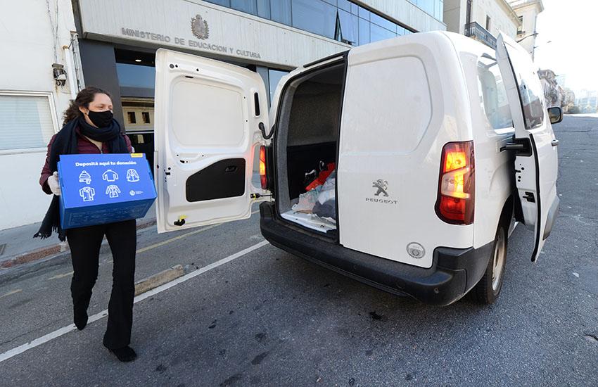 mujer caminando con caja azul y camioneta