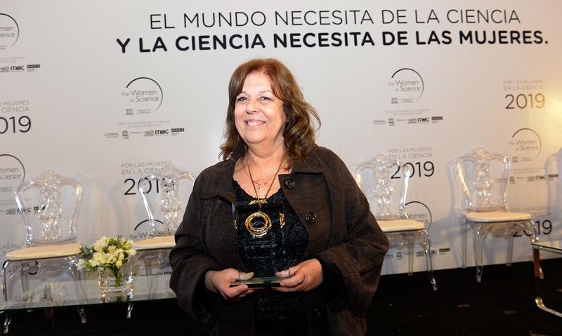 La Dra. Mónica Sans sonriente con el Premio L´Oreal - Unesco entre sus manos