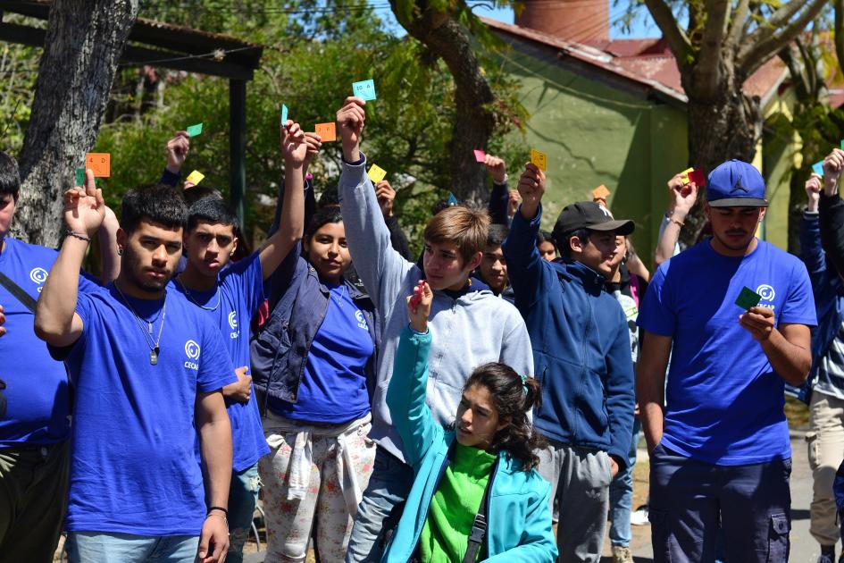 Jóvenes levantando papeles de colores al aire