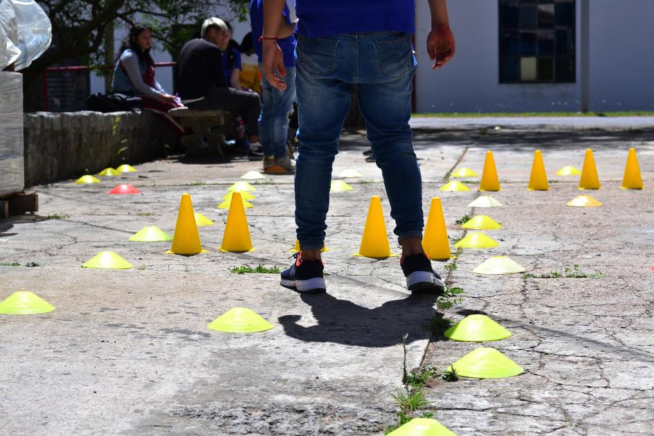 Persona caminando con los ojos vendados por un circuito delimitado por conos