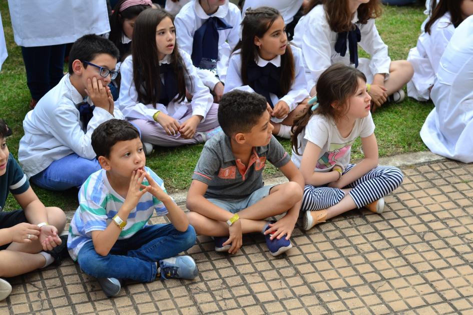 Niños escolares presenciando el acto de apertura