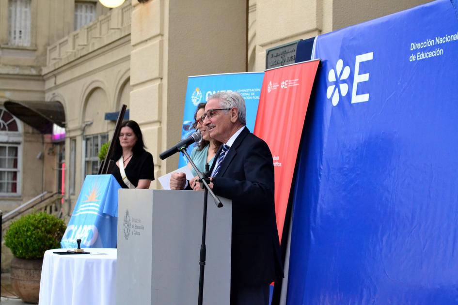 Hombre de pie dando un discurso con un atril