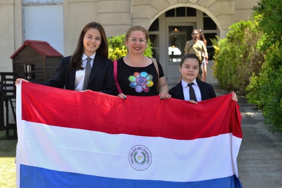 Personas de pie sosteniendo bandera de Paraguay
