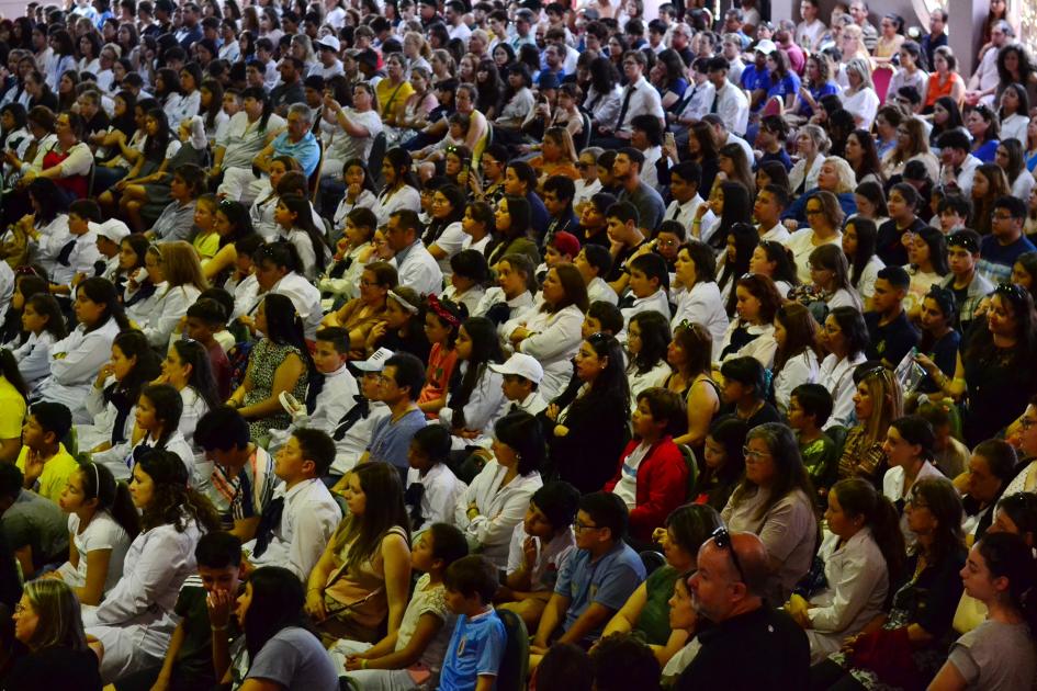 Multitud de niños y maestras presenciando un acto