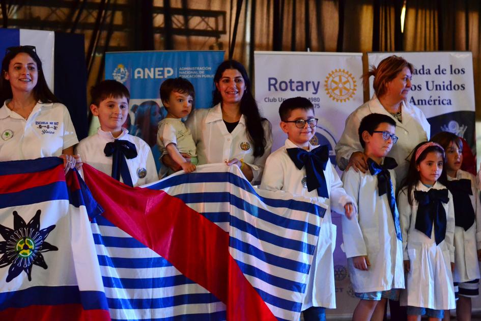 Nueve personas posando con la bandera de Canelones