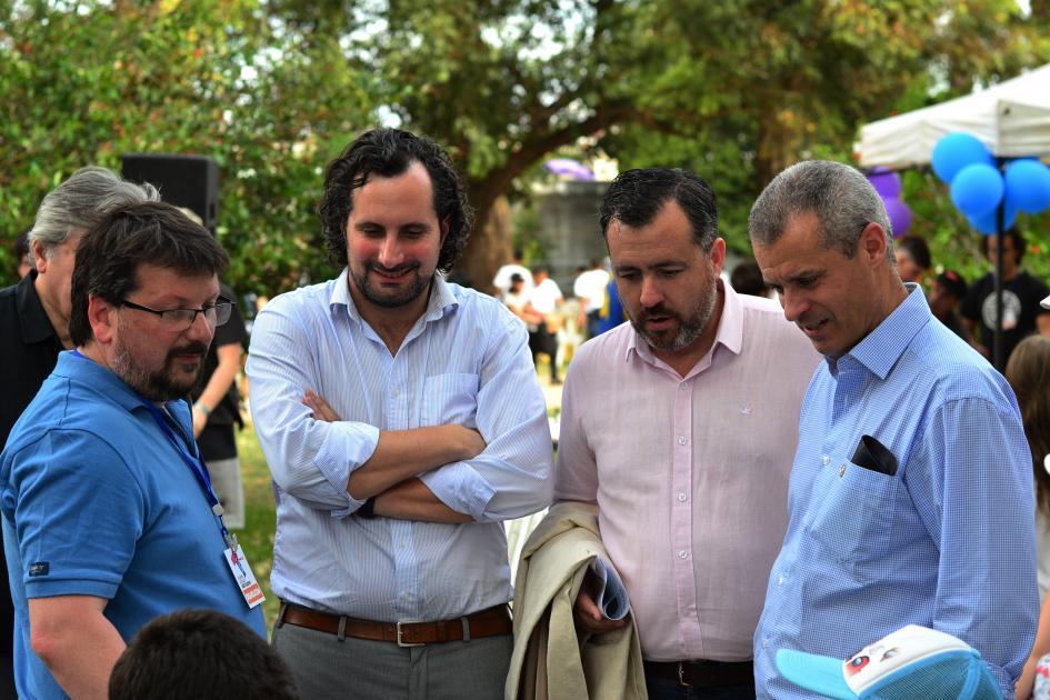 Cuatro hombres en ronda observando una partida de ajedrez