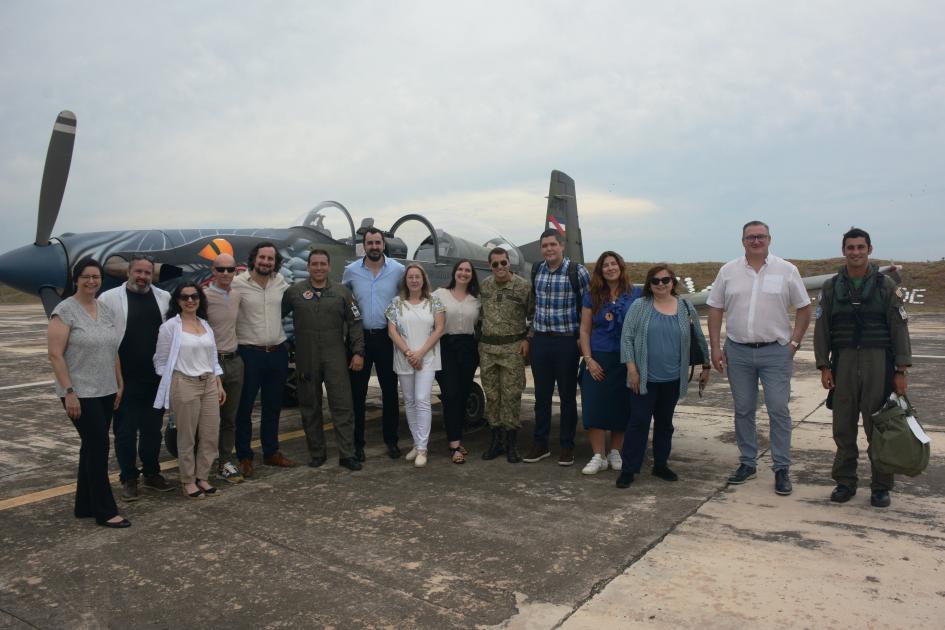 Personas en fila posando delante de un avión