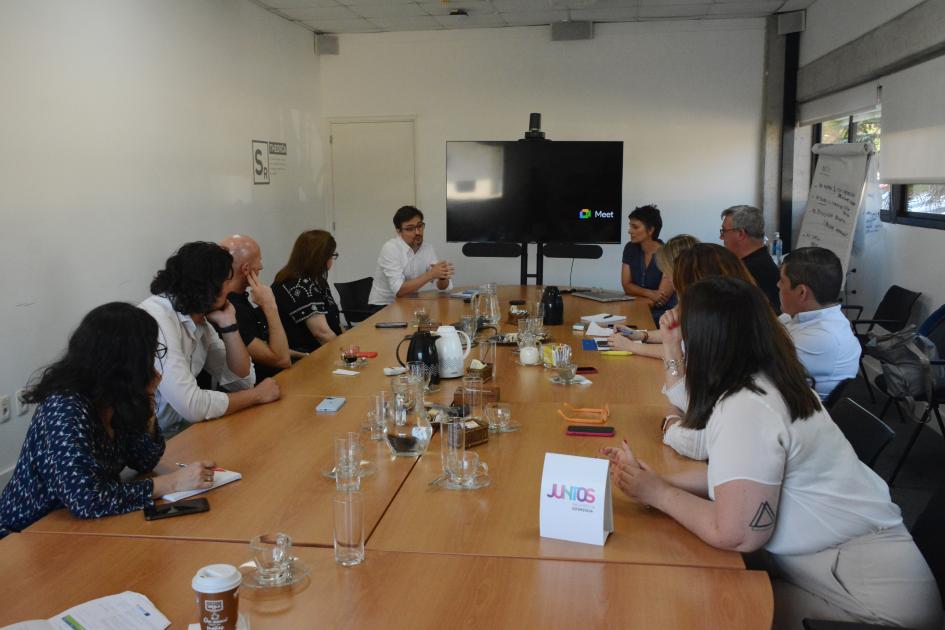 Personas sentadas en ronda alrededor de una mesa