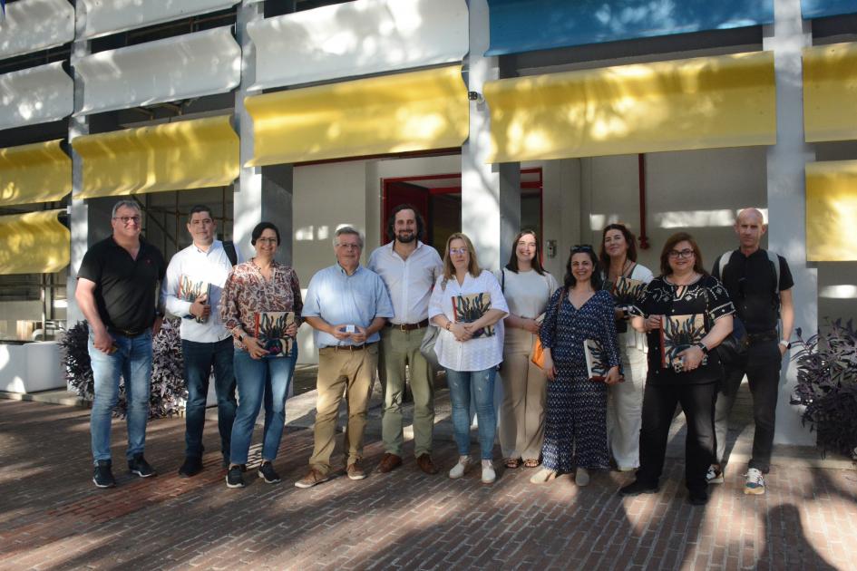 Personas en fila posando delante de la fachada del museo