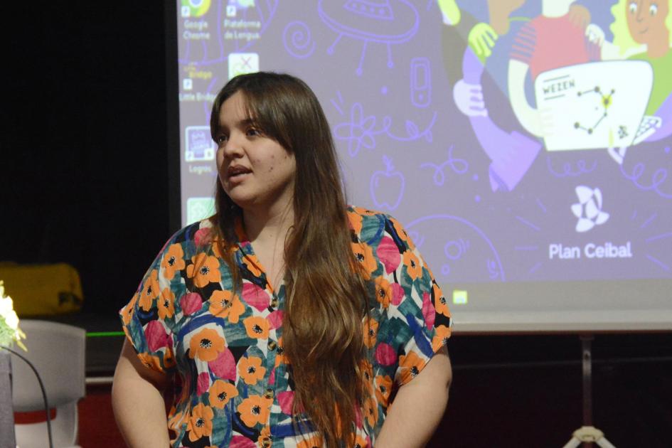 Mujer de pie frente a un auditorio