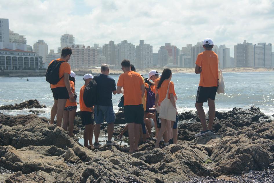 Personas caminando entre las rocas próximos al océano