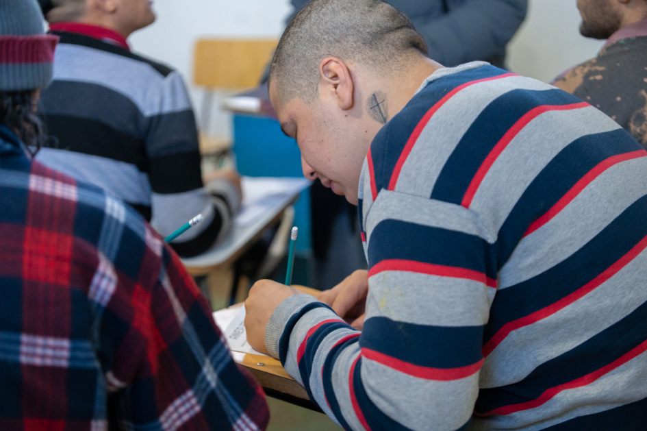 Persona escribiendo en un salón de clase