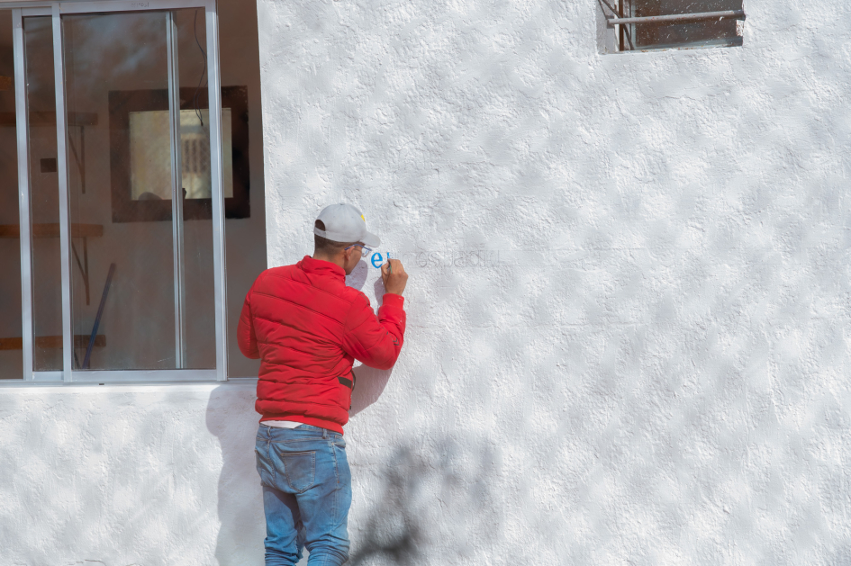 Hombre pintando letras en una pared