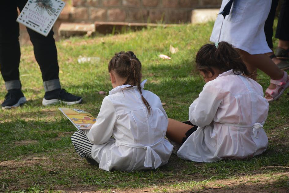 Niños de espaldas leyendo un libro