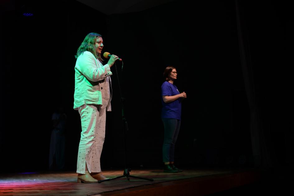 dos mujeres de pie en escenario.