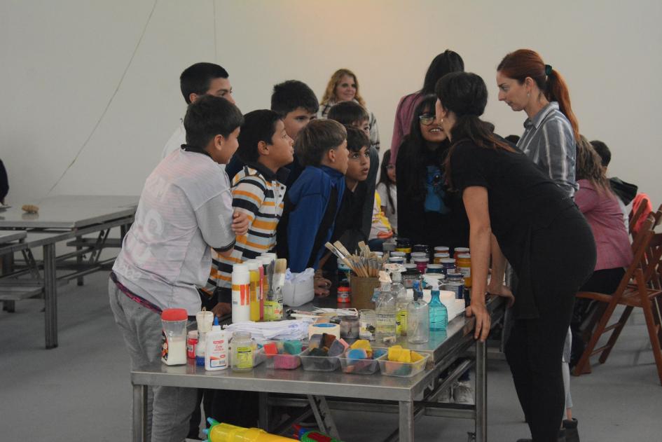 Niños alrededor de una mesa con pinturas