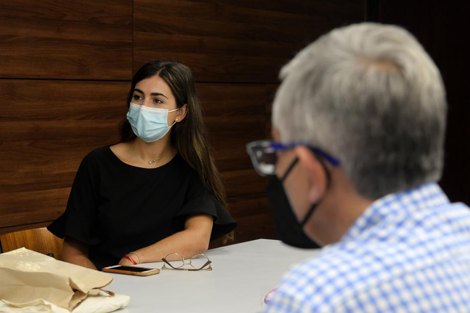 mujer sentada y hombre de espaldas