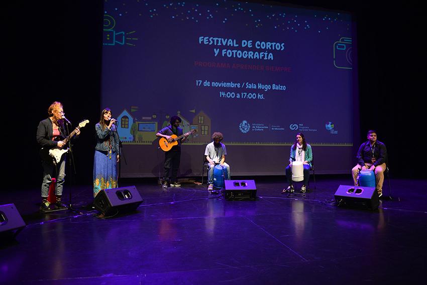 cinco personas en escenario haciendo música