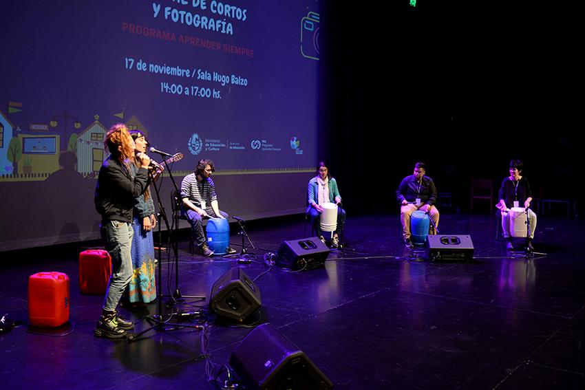cinco personas en escenario haciendo música