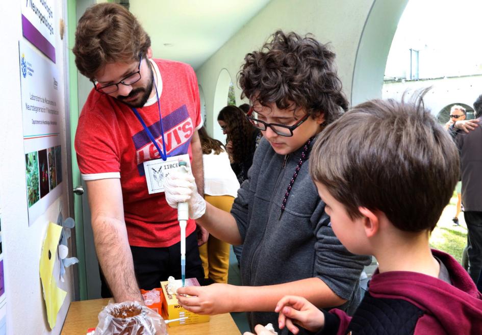 Un joven visitante del IIBCE Abierto aprende a usar la pipeta Un joven visitante del IIBCE Abierto aprende a usar la pipeta