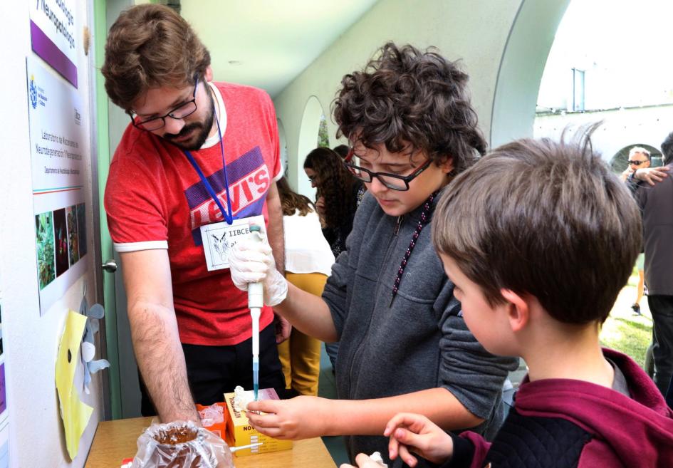 Un joven visitante del IIBCE Abierto aprende a usar la pipeta