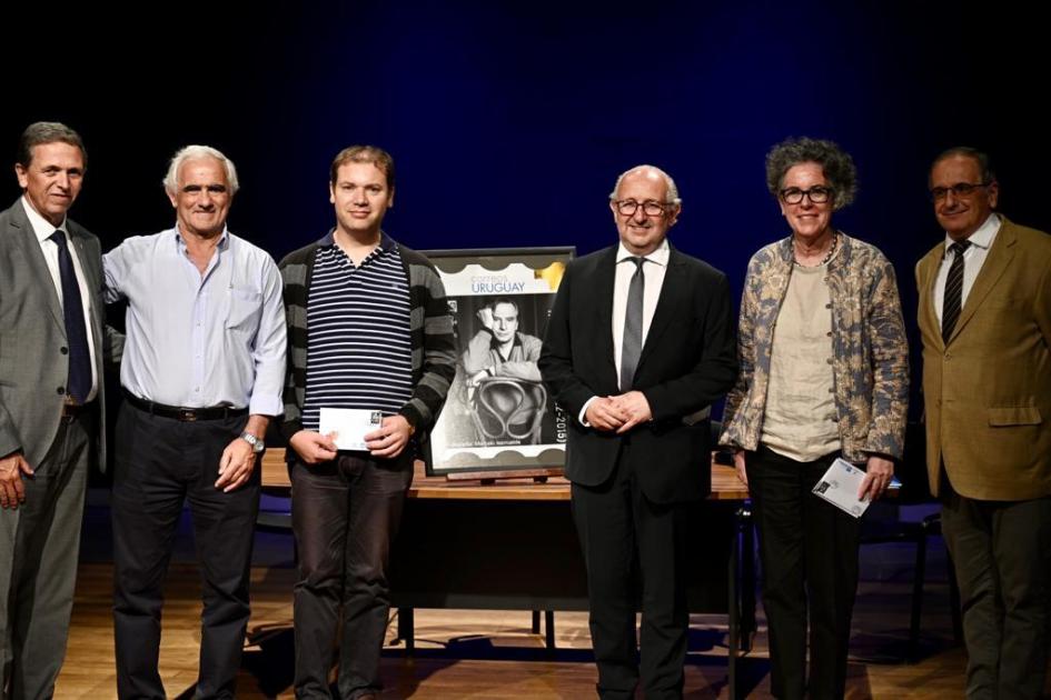 Presentación del sello homenaje a "Taco" Larreta. Personas paradas junto a gigantografía del sello.