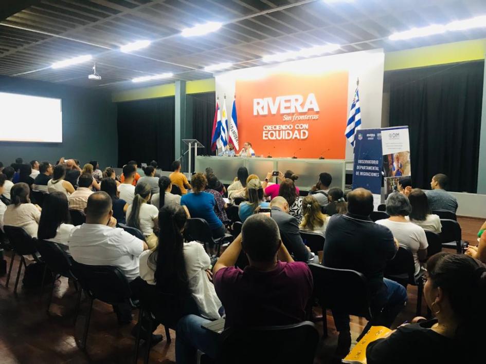 En un auditorio se encuentran personas sentadas participando del taller