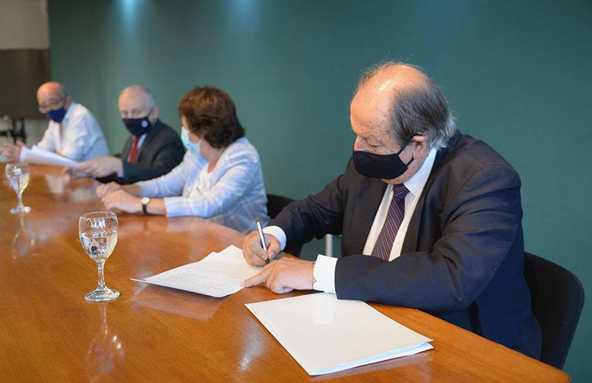 Andrés Gil integrante del Consejo Directivo de UTEC durante la firma persona firmando documento