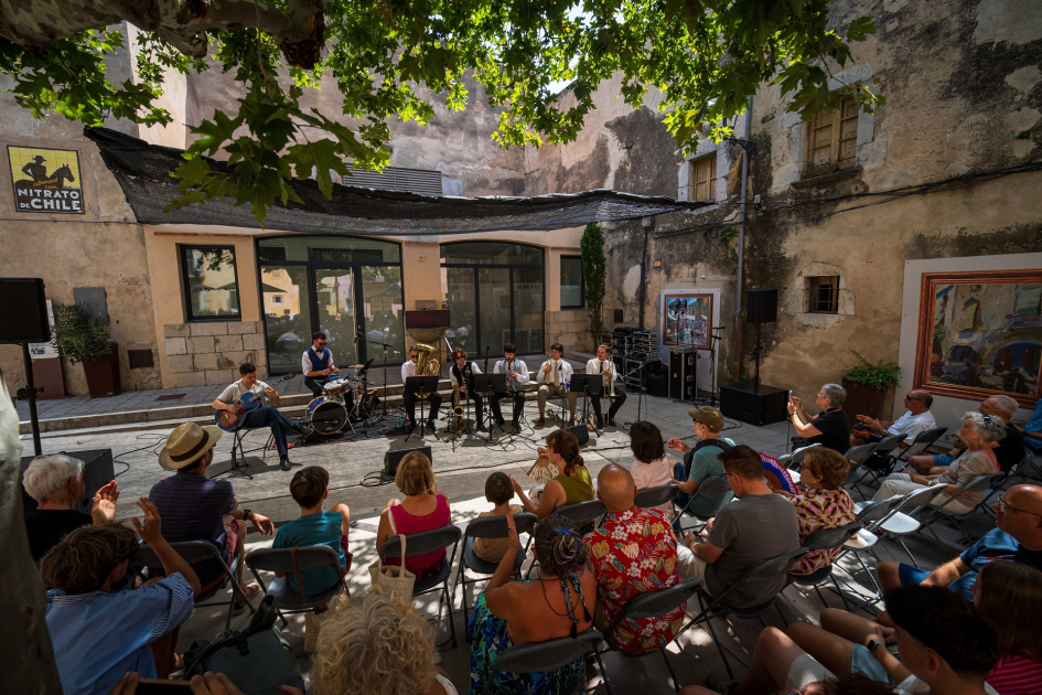 Plano general de un escenario al aire libre con músicos tocando en vivo