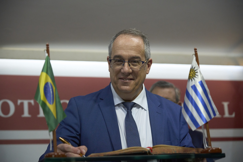 Ministro Mahía desarrolla una intensa agenda en el marco de la Semana de Uruguay en Río Ministro Mahía firma documento en un atril
