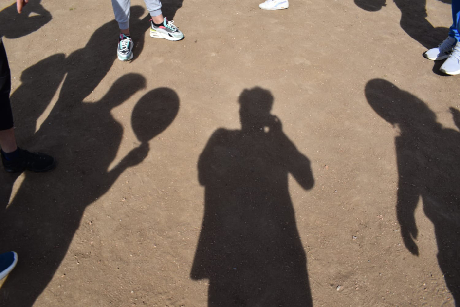 Sombras de personas en el suelo con una pelota